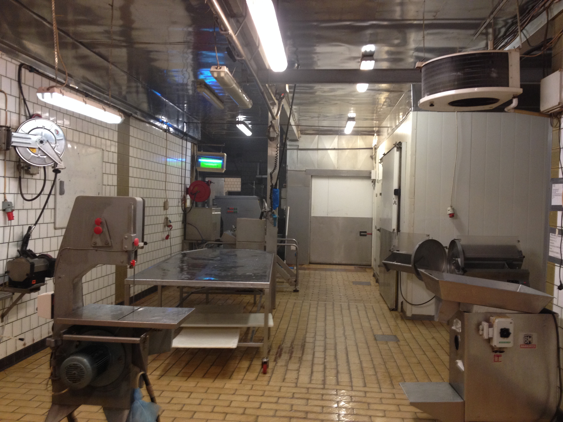 Inne i slakteriet — bandsåg, kvarn och kylrum